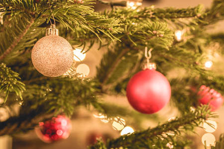 Gold and red christmas baubles in a christmas treeの写真素材