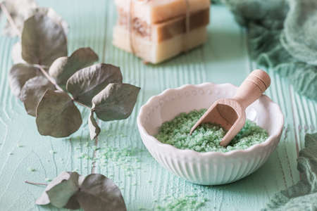 Eucalyptus bath salt in a white bowl on light green background, wellness conceptの写真素材