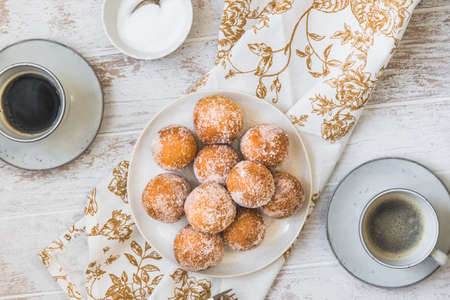Fried curd balls with sugar on white wooden background, top view. Concept of coffee break. Copyspace.の写真素材