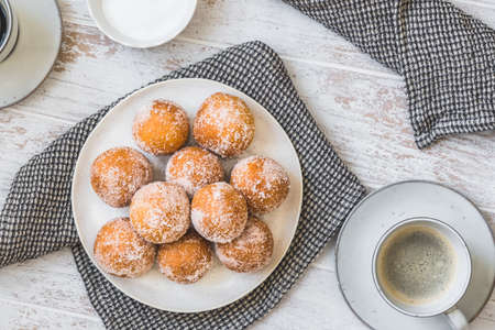 Fried curd balls with sugar on white wooden background, top view. Concept of coffee break. Copyspace.の写真素材