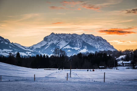 View to the Austrian mountain called Wilder Kaiser from german village Reit im Winkl in beautiful sunset light, copy spaceの写真素材