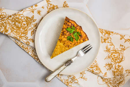 Piece of a potato cake, spanish tortilla, frittata, on a white table on white background, top viewの写真素材