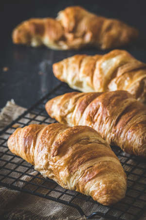 Row of delicious French croissants on black background, verticalの写真素材
