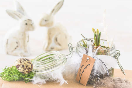 Mini hyacinth in mason jar decorated with feathers and easter bunny, spring or easter decorationの写真素材