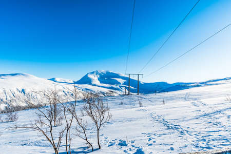 Snowy mountain and blue sky in Norway on a sunny winter day, copy space