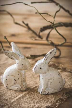 Wooden decoration Easter bunnies with small quail eggs and natural decoration on rustic wooden background, verticalの写真素材