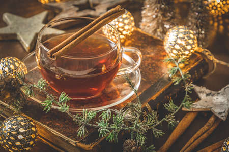 Glass of tea on a wooden table decorated for Christmasの写真素材