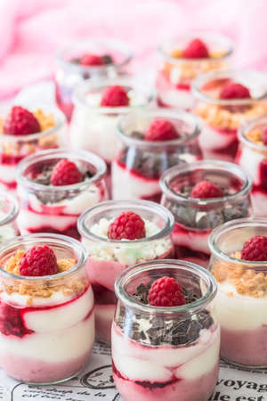 Fruity quark dessert with raspberries and chocolate or crisp topping in small glassesの写真素材