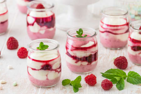 Fruity quark dessert with raspberries and chocolate or crisp topping in small glassesの写真素材