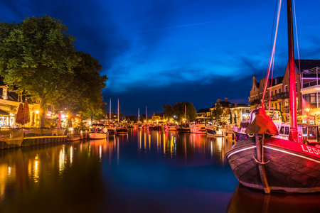 View of the illuminated historical part of the city of Lemmer in Friesland, Netherlands after sunsetの写真素材