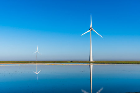 Wind turbines on a summer day with a beautiful reflection in the waterの写真素材