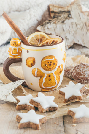 Cup with mulled wine or punch or spiced tea with christmas cookies, harmonious light colors, vertical stock photoの写真素材