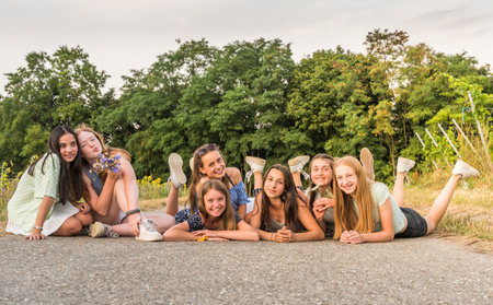 Seven teenage girls lying on a street, copy spaceの写真素材