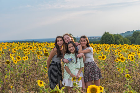 Teenage girls having fun in a sunflower field on a late summer afternoon. Copyspace.の写真素材