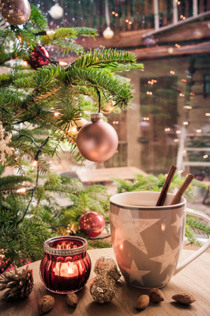 Cup of tea on a coffee table next to a Christmas tree, harmonious afternoon Christmas scene, verticalの写真素材