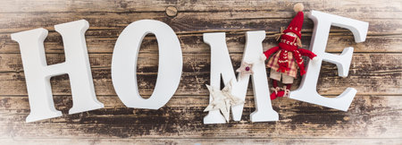 Home - white letters with small christmas decoration on old woodの写真素材