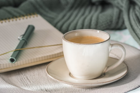 Cup of coffee and cookies on cozy bed. Warm wool sweater for a cozy autumn weekend, breakfast in bed, coffee break. Hygge concept.の写真素材