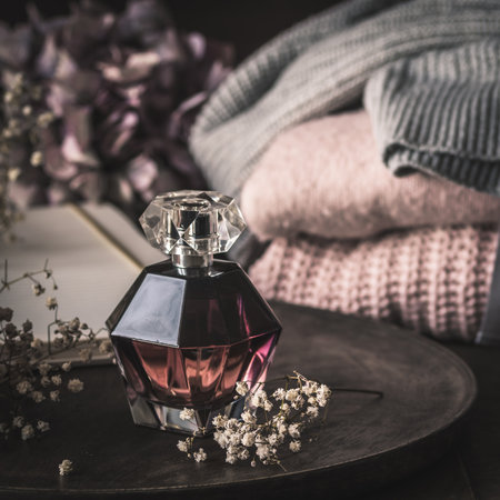 Perfume bottle with decoration on wooden tray, verticalの写真素材