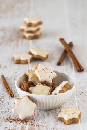 Christmas cinnamon star cookies on a white wooden table, verticalの写真素材