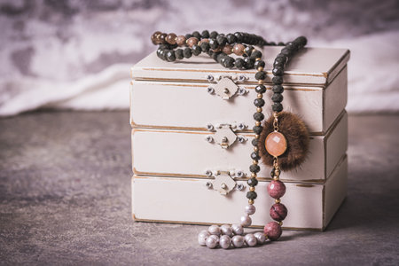 Necklace with pearls, costume jewelry, on a white wooden jewelry box, gray, white and pink colors, gray background, vintage styleの写真素材