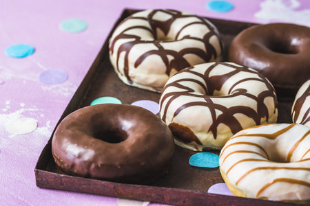 Chocolate Donuts, Berliner, Krapfen on a rusty tray on pink backgroundの写真素材