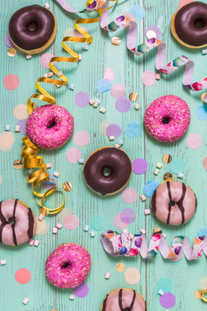 Donuts, donuts, donuts with streamers and confetti. Colorful picture of carnival, birthday and fasching, green background, top viewの写真素材