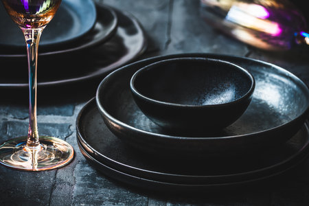 Black stoneware and pink shimmering champagne glasses on a rustic black tableの写真素材