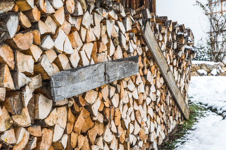 Stacked pile of firewood at winter timeの写真素材