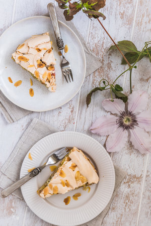 Pieces of rhubarb pie with meringue topping and almonds on white wooden background, top viewの写真素材