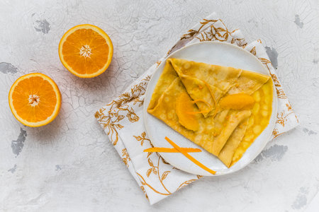Crepe Suzette, french thin pancake with orange sauce and fruits, white background, top view with copy spaceの写真素材