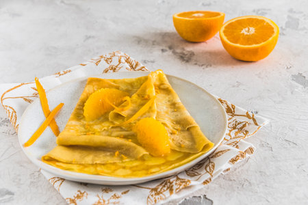 Crepe Suzette, french thin pancake with orange sauce and fruits, on white backgroundの写真素材