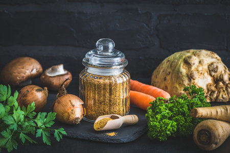 Homemade vegetable broth powder, organic vegetable stock, with raw vegetables on black background, copy spaceの写真素材