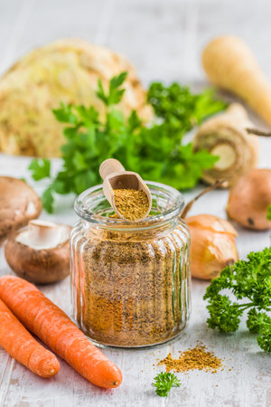 Homemade vegetable broth powder, organic vegetable stock, with raw vegetables on white wooden background, verticalの写真素材