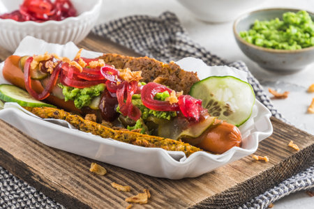 Homemade healthy vegetarian hot dog with flatbread made from vegetables, topped with red onions, pickles and pea pureeの写真素材