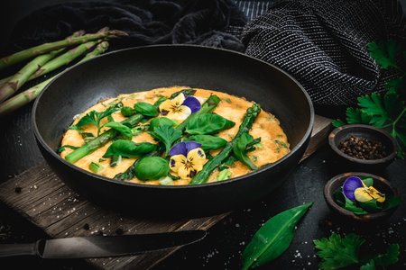 Omelette with green asparagus, basil and herbs on black backgroundの写真素材