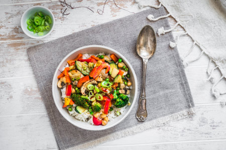 Bowl with rice and vegetables on white wooden table, vegetarian, vegan, healthy food, top viewの写真素材