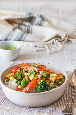 Bowl with rice and vegetables on white wooden table, vegetarian, vegan, healthy foodの写真素材