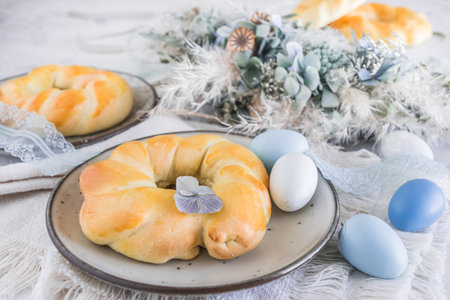 Homemade easter buns on a table decorated for easter brunch or breakfastの写真素材