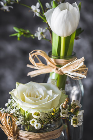 Floral spring decoration with white rose and tulip on gray background, verticalの写真素材