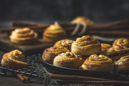 Cinnamon rolls on a black table on dark wooden backgroundの写真素材