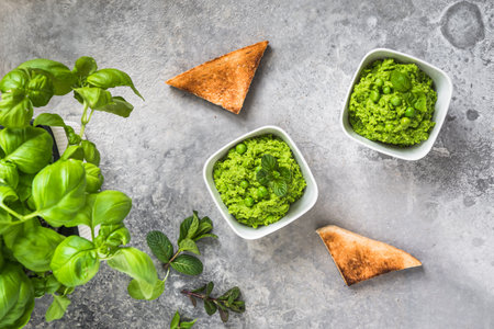 Pea puree with basil and roasted bread on rustic gray background, top viewの写真素材