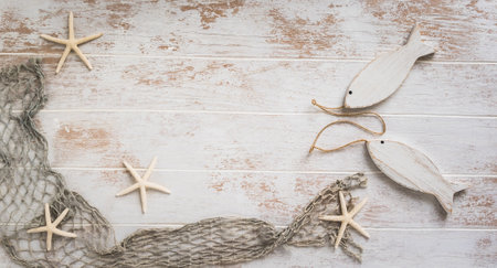 Seashells and starfish on a white wooden background. Holiday and vacation concept. Top view, copy space.の写真素材