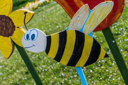 Bee and flowers sawn from wood as decoration in a public parkの写真素材
