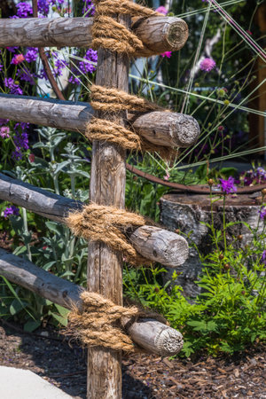 Garden fence made of wooden posts and ropesの写真素材