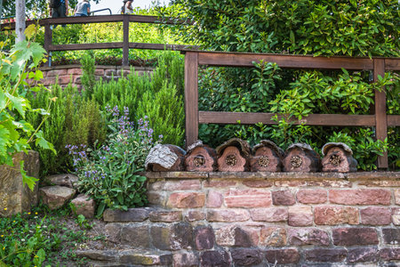 Natural garden with stone wall, native plants and insect hotels, bug hotels, insect houses. Natural gardening concept.の写真素材