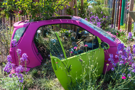 Old pink and green car used as decoration and flower pot in a gardenの写真素材
