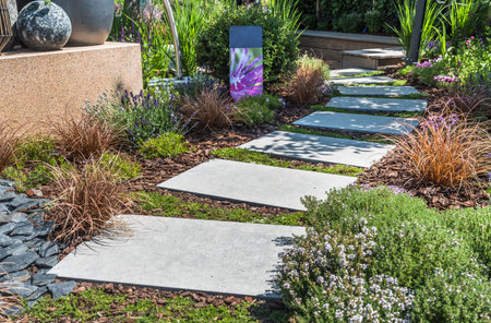 Path with large stone slabs through a beautifully planted gardenの写真素材