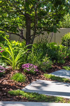 Path with large stone slabs through a beautifully planted garden, verticalの写真素材