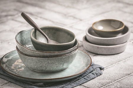 Gray stoneware plates and bowls on a rustic table, copy spaceの写真素材
