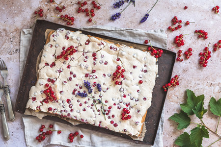 Whole currant cake with crispy meringue on top and fresh fruits as decoration, top viewの写真素材